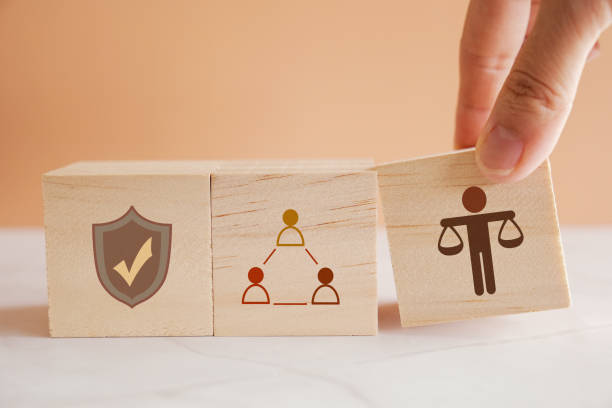 Hand holding wooden block with human scale, business ethics and corporate compliance concept