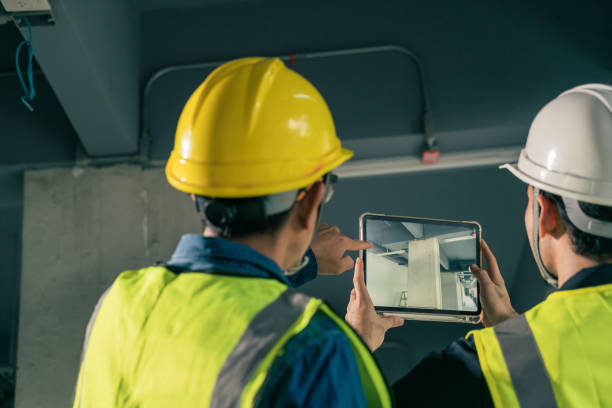 Selective focus Tablet on hand Civil Engineer and Contractor working in construction site. Team Architect working use BIM technology and digital construction application on digital tablet